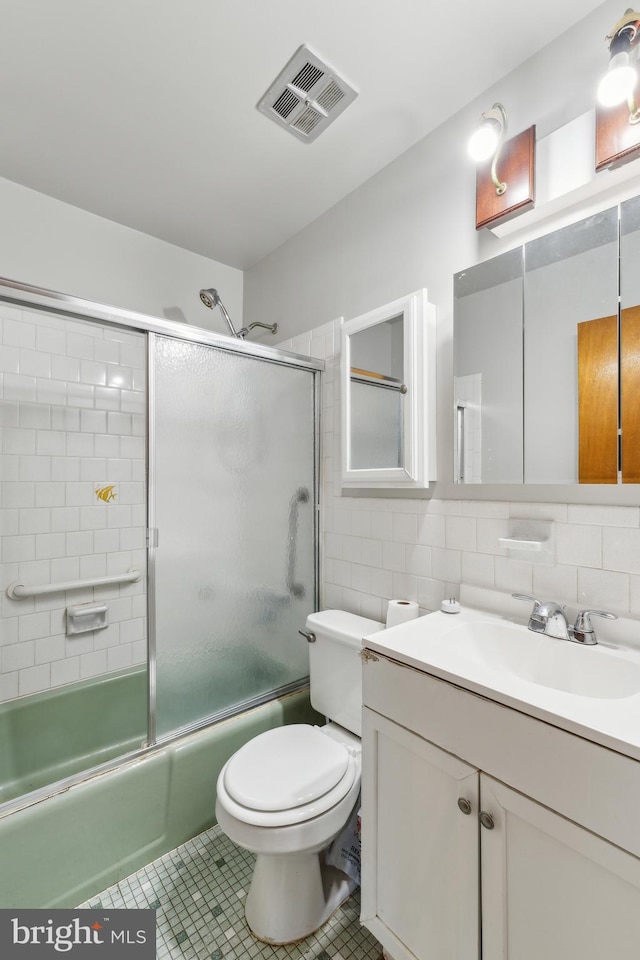 8601 Pretoria Ct, Clinton, MD 20735 - bathroom with combined bath / shower with glass door, visible vents, toilet, vanity, and tile walls