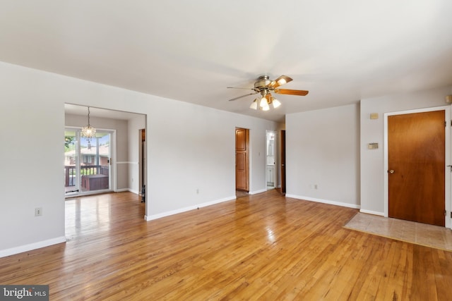8601 Pretoria Ct, Clinton, MD 20735 - unfurnished living room featuring light wood-type flooring, baseboards, and ceiling fan with notable chandelier