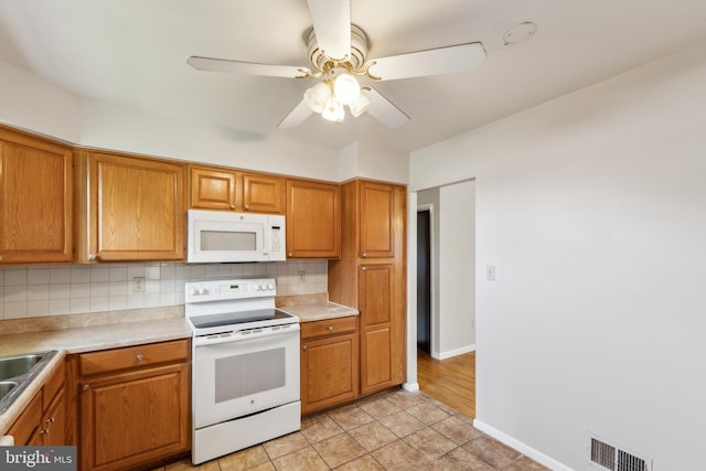 8601 Pretoria Ct, Clinton, MD 20735 - kitchen with brown cabinets, backsplash, visible vents, a ceiling fan, and white appliances