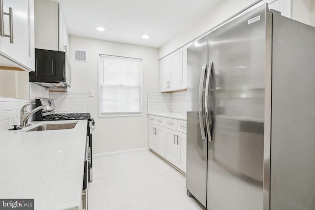 2305 Houston St, Suitland, MD 20746 - kitchen featuring stainless steel appliances, decorative backsplash, white cabinets, recessed lighting, and light stone counters