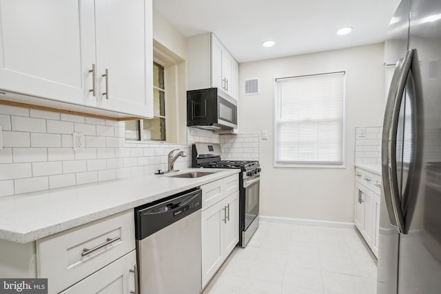 2305 Houston St, Suitland, MD 20746 - kitchen featuring stainless steel appliances, white cabinetry, tasteful backsplash, light stone counters, and recessed lighting