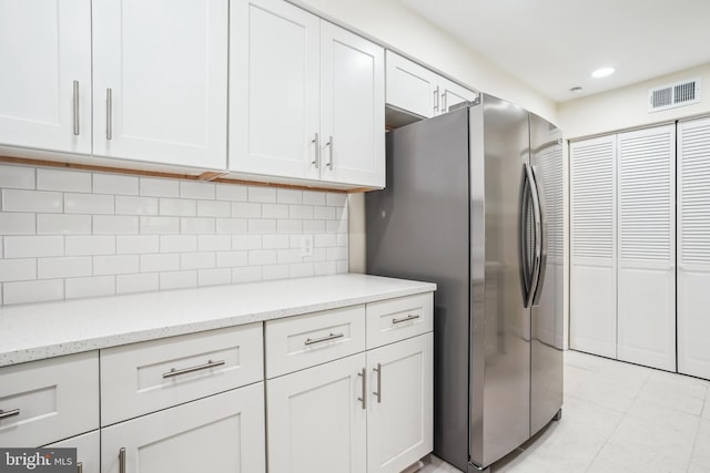 2305 Houston St, Suitland, MD 20746 - kitchen with freestanding refrigerator, white cabinetry, light tile patterned flooring, tasteful backsplash, and recessed lighting