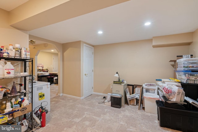 finished basement with arched walkways, baseboards, and recessed lighting