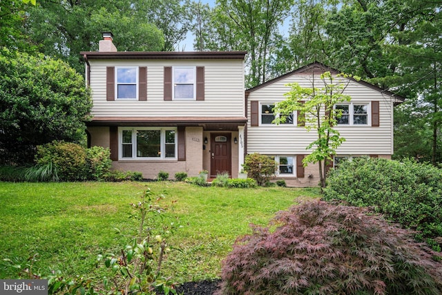 4705 Exeter St, Annandale, VA 22003 - tri-level home with a chimney, a front lawn, and brick siding