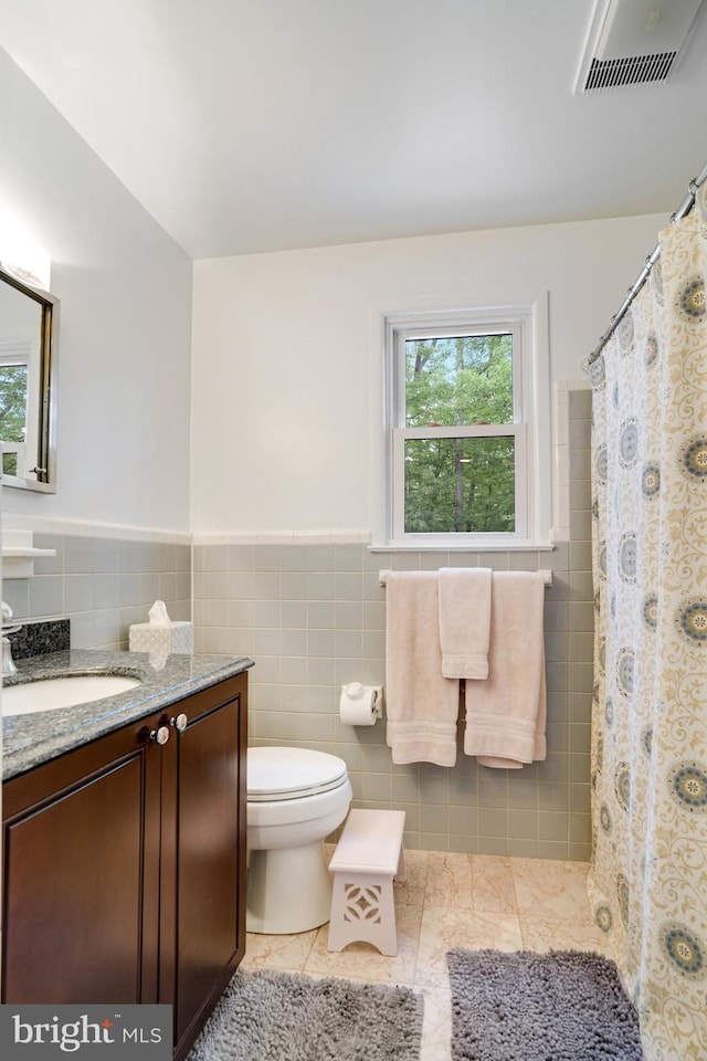 4705 Exeter St, Annandale, VA 22003 - bathroom with vanity, tile walls, toilet, a wainscoted wall, and tile patterned floors