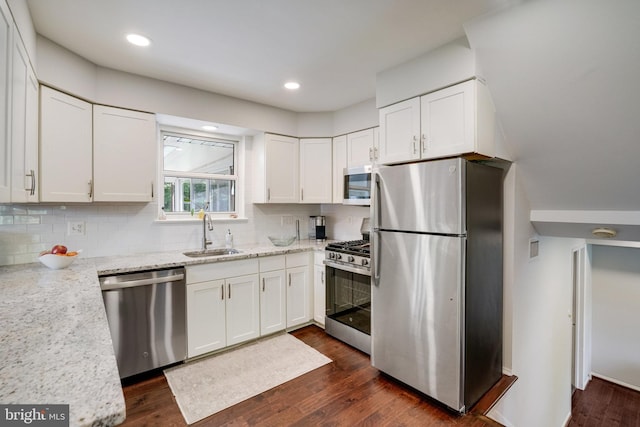 4705 Exeter St, Annandale, VA 22003 - kitchen with appliances with stainless steel finishes, a sink, white cabinets, dark wood-style flooring, and backsplash