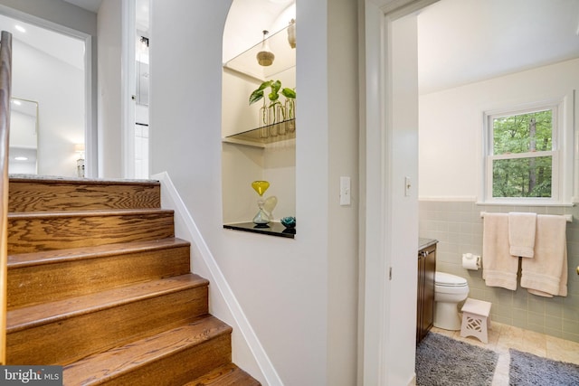4705 Exeter St, Annandale, VA 22003 - staircase with tile patterned floors, tile walls, and wainscoting