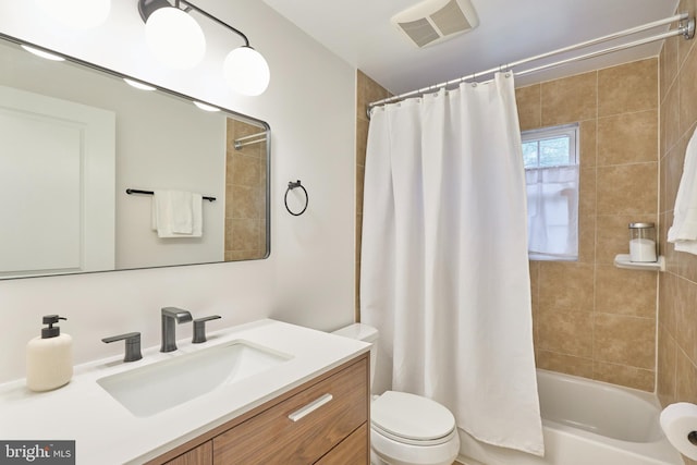 full bathroom featuring toilet, shower / bath combo, vanity, and visible vents