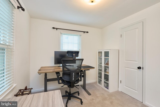 carpeted home office featuring baseboards