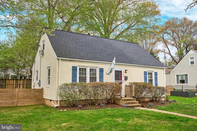 cape cod home with a front yard, fence, and roof with shingles