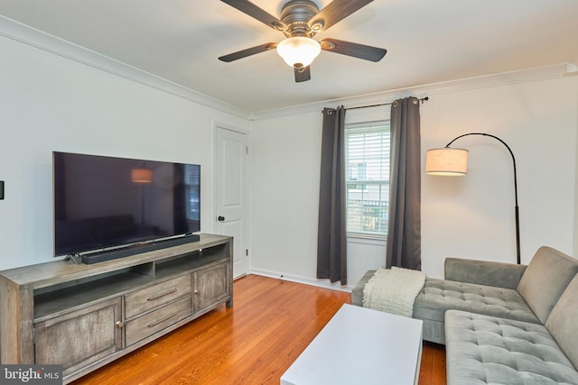 living area featuring light wood-style flooring, crown molding, and ceiling fan