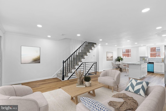 living room featuring light wood finished floors, recessed lighting, and stairs
