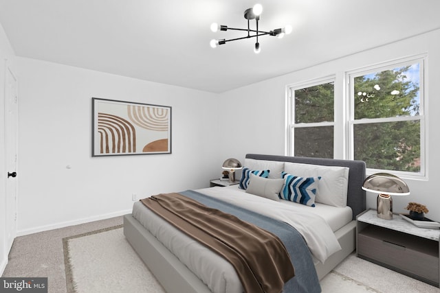 bedroom with an inviting chandelier, baseboards, and carpet floors