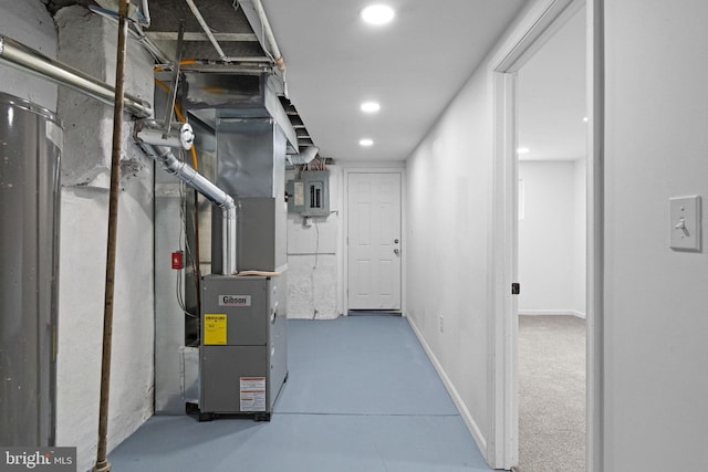 basement featuring baseboards, heating unit, electric panel, and recessed lighting