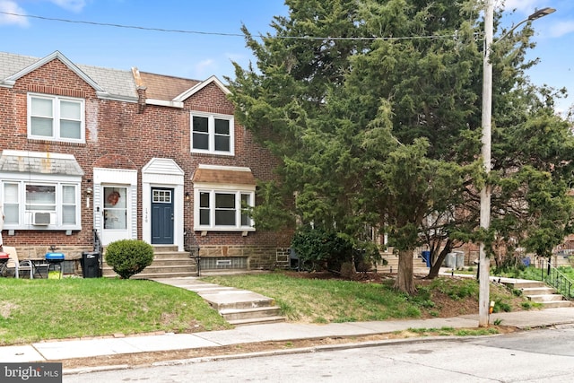 multi unit property featuring brick siding and a front yard