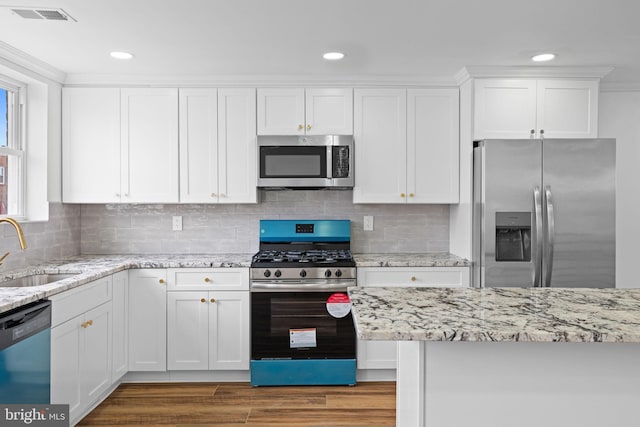 kitchen featuring light wood-style floors, white cabinetry, visible vents, a sink, and stainless steel appliances