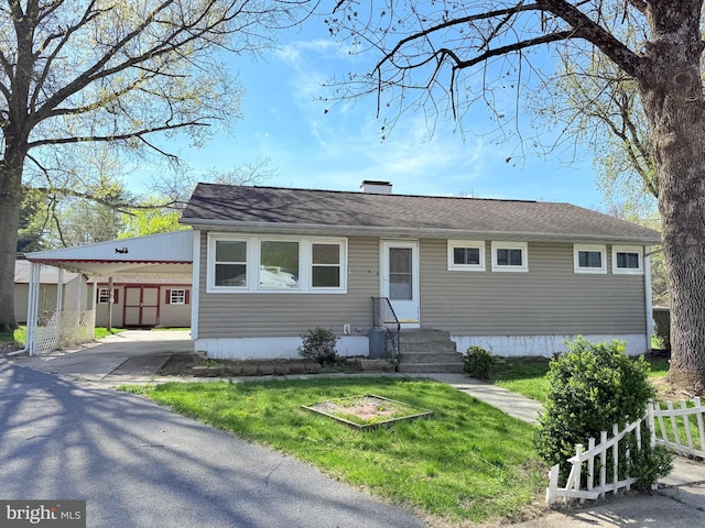 view of front of home featuring driveway, fence, a front lawn, entry steps, and an attached carport