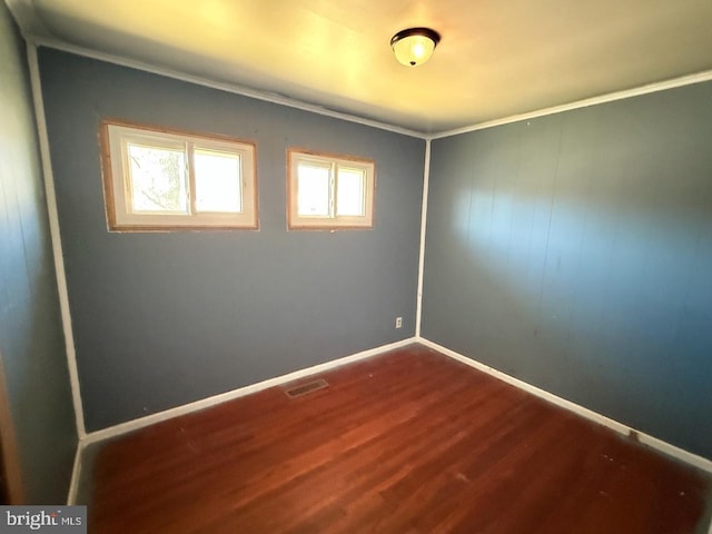 spare room with visible vents, dark wood finished floors, and baseboards