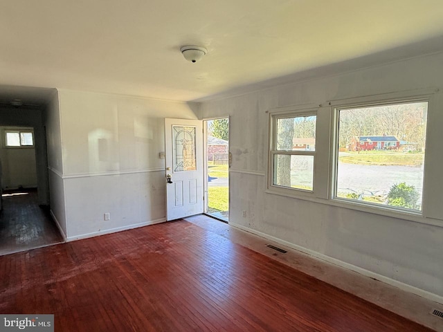foyer entrance featuring baseboards, hardwood / wood-style flooring, and visible vents