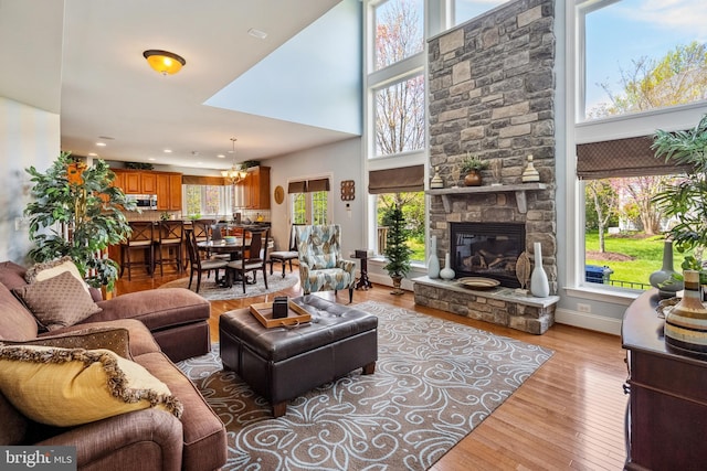 3716 Taft Ave, Alexandria, VA 22304 - living area featuring a fireplace, light wood-type flooring, a towering ceiling, and baseboards