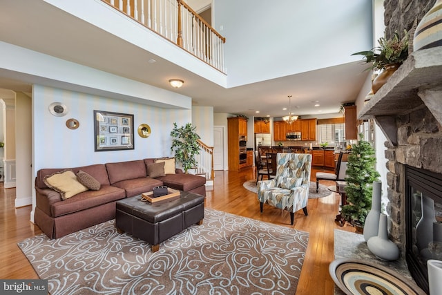 3716 Taft Ave, Alexandria, VA 22304 - living room with recessed lighting, light wood-type flooring, a towering ceiling, and a stone fireplace