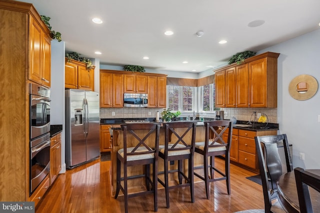 3716 Taft Ave, Alexandria, VA 22304 - kitchen with brown cabinets, dark countertops, light wood-style flooring, and stainless steel appliances