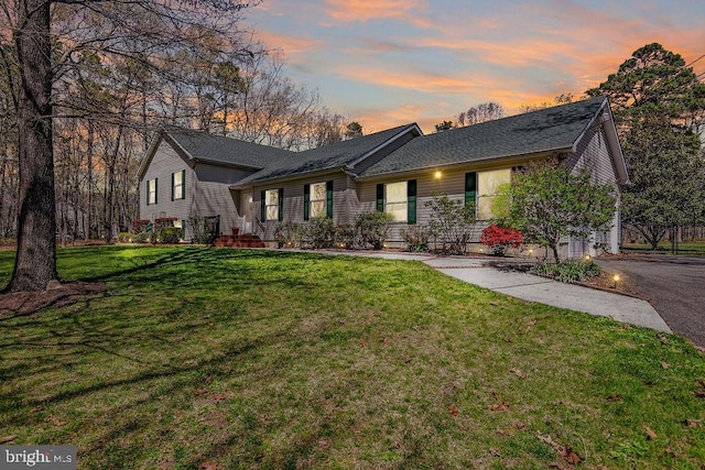 tri-level home featuring a front yard and roof with shingles