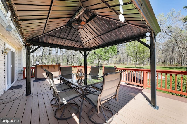 deck with a gazebo and outdoor dining space