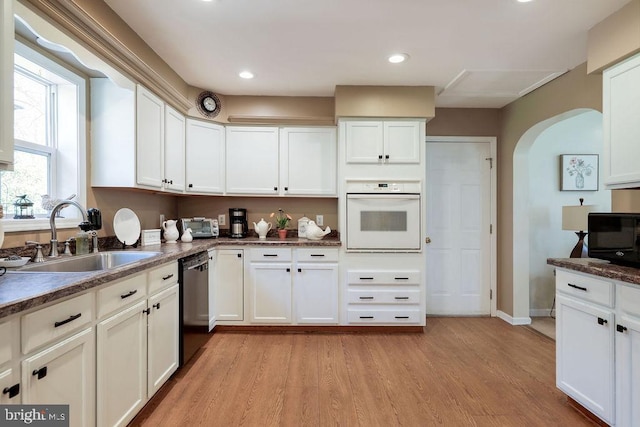 kitchen featuring a sink, white cabinets, black appliances, light wood-style floors, and recessed lighting