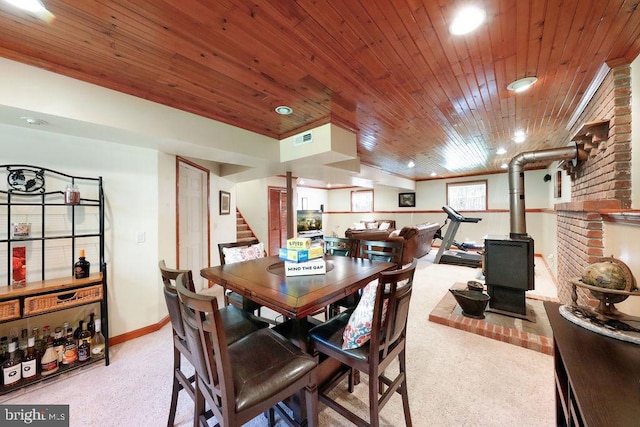 dining space featuring a wood stove, stairs, baseboards, recessed lighting, and wood ceiling
