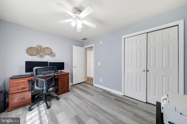 office area featuring light wood-style floors, baseboards, a ceiling fan, and visible vents