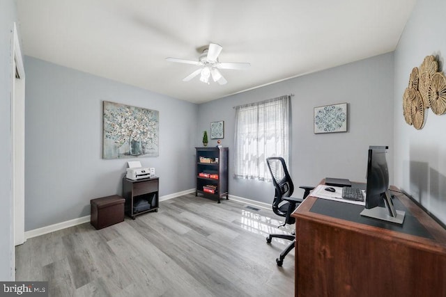 home office with baseboards, a ceiling fan, wood finished floors, and visible vents