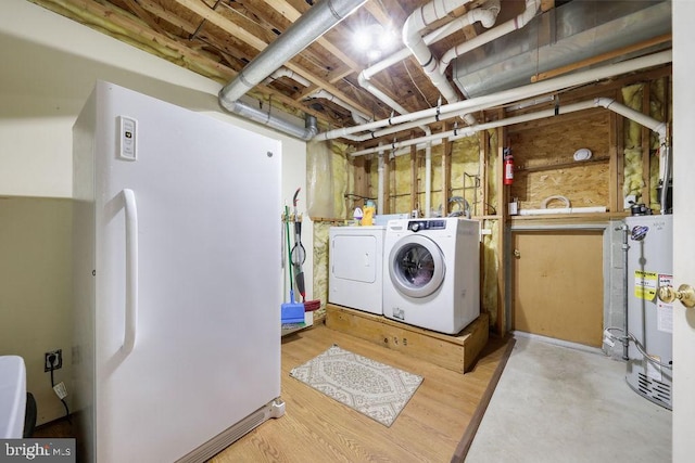 clothes washing area with separate washer and dryer, laundry area, and gas water heater