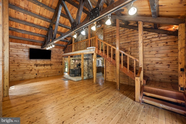 74 Madison Rd, Elmer, NJ 08318 - unfurnished living room featuring wooden walls, a wood stove, wood-type flooring, stairway, and wood ceiling