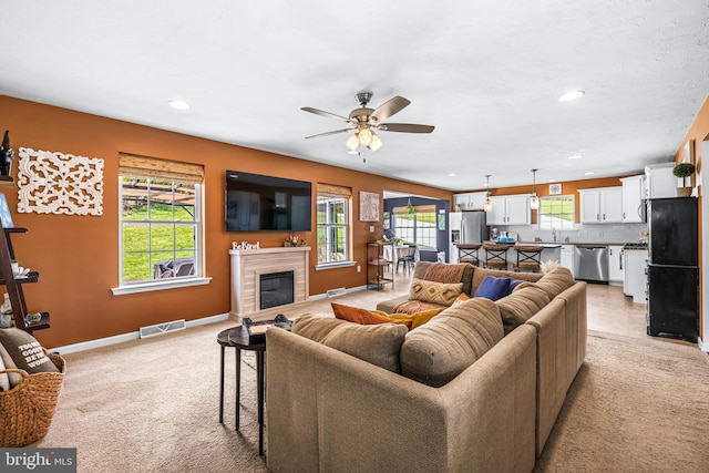 living room with visible vents, light carpet, and a healthy amount of sunlight