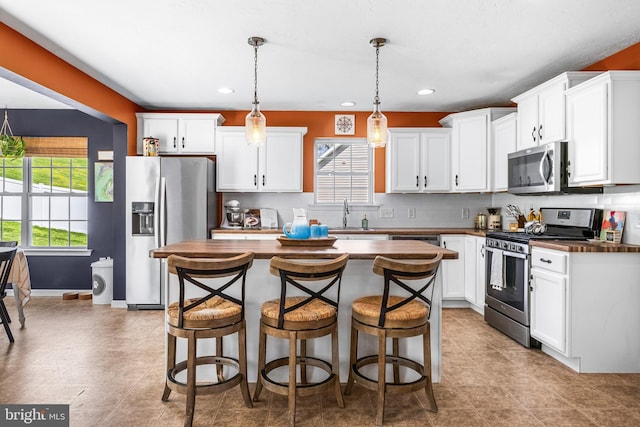 kitchen with a sink, white cabinetry, stainless steel appliances, and recessed lighting
