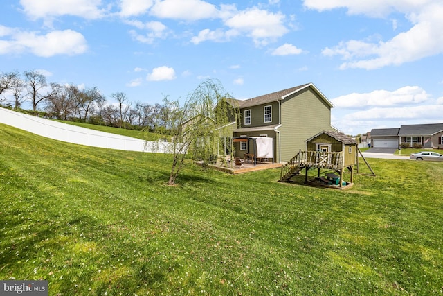 rear view of property with a yard, a patio, a playground, and fence