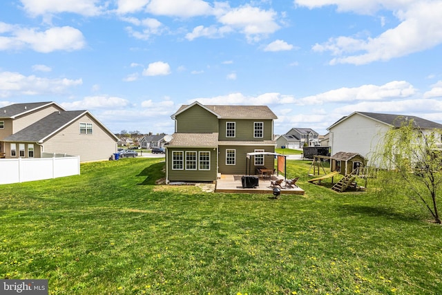rear view of house featuring a wooden deck, a residential view, a lawn, and fence