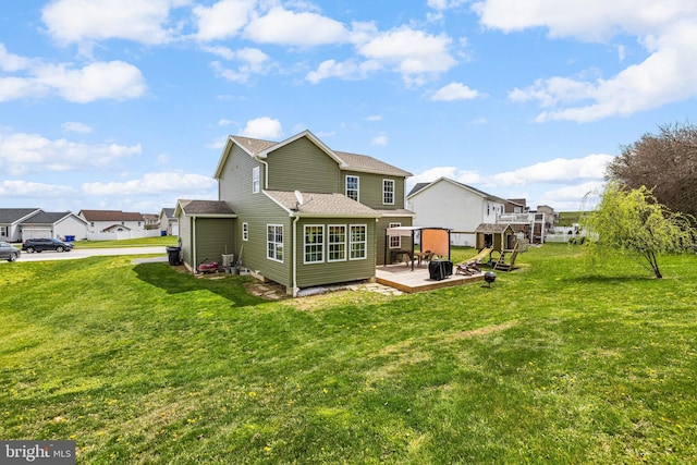 rear view of house with a lawn, a shingled roof, central air condition unit, and a deck