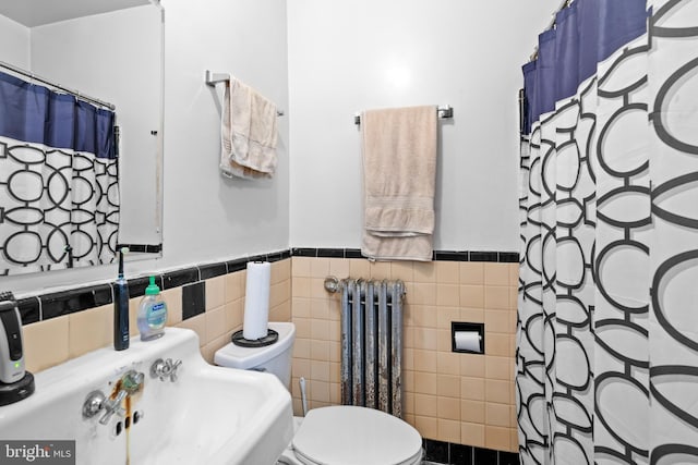 bathroom featuring radiator heating unit, a shower with shower curtain, tile walls, and toilet
