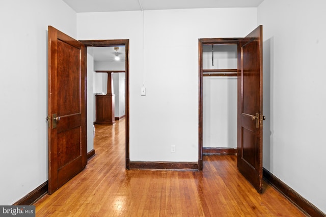 unfurnished bedroom featuring a closet, baseboards, and hardwood / wood-style floors