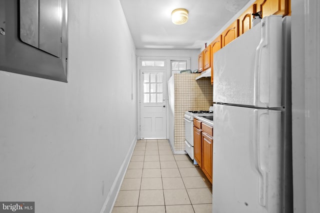 kitchen featuring light tile patterned floors, white appliances, brown cabinetry, electric panel, and baseboards