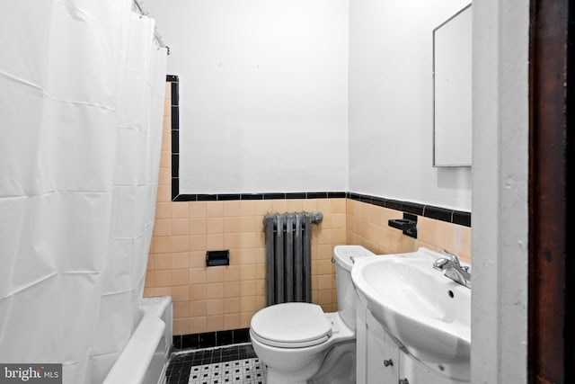 bathroom with vanity, tile patterned flooring, toilet, radiator, and tile walls