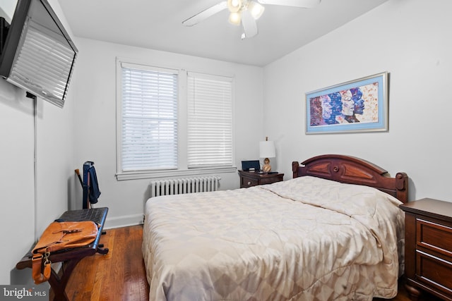 bedroom with radiator, wood finished floors, baseboards, and a ceiling fan