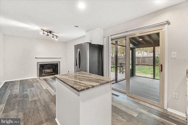 8794 Inspiration Ct, Walkersville, MD 21793 - kitchen featuring white cabinets, dark wood-style floors, stainless steel fridge with ice dispenser, visible vents, and a center island