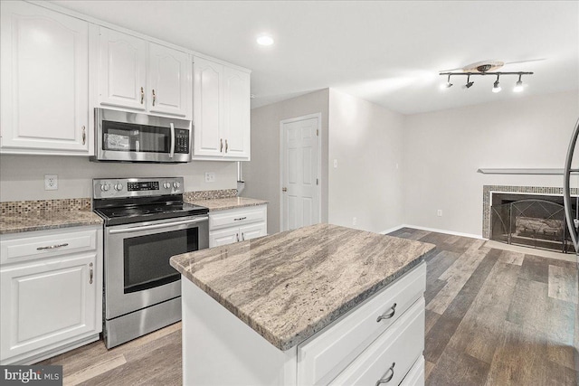8794 Inspiration Ct, Walkersville, MD 21793 - kitchen with a center island, light wood-type flooring, white cabinets, appliances with stainless steel finishes, and light stone countertops