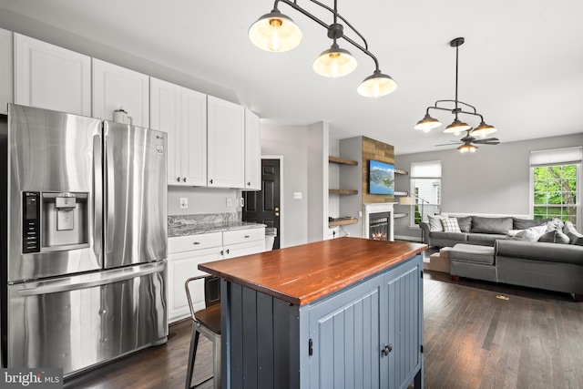 kitchen with stainless steel fridge, wood counters, dark wood finished floors, white cabinetry, and a ceiling fan