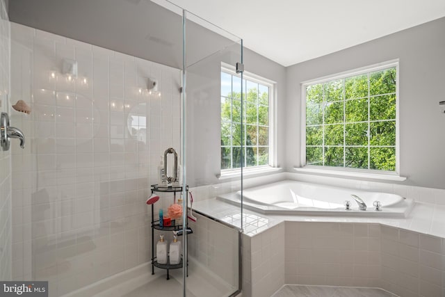 bathroom with a shower stall and a garden tub