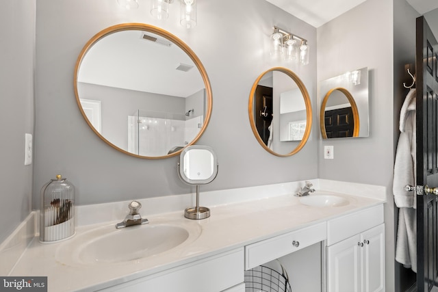 bathroom with a sink, walk in shower, double vanity, and visible vents