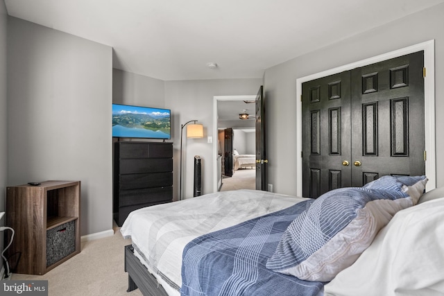 bedroom with light carpet and a closet